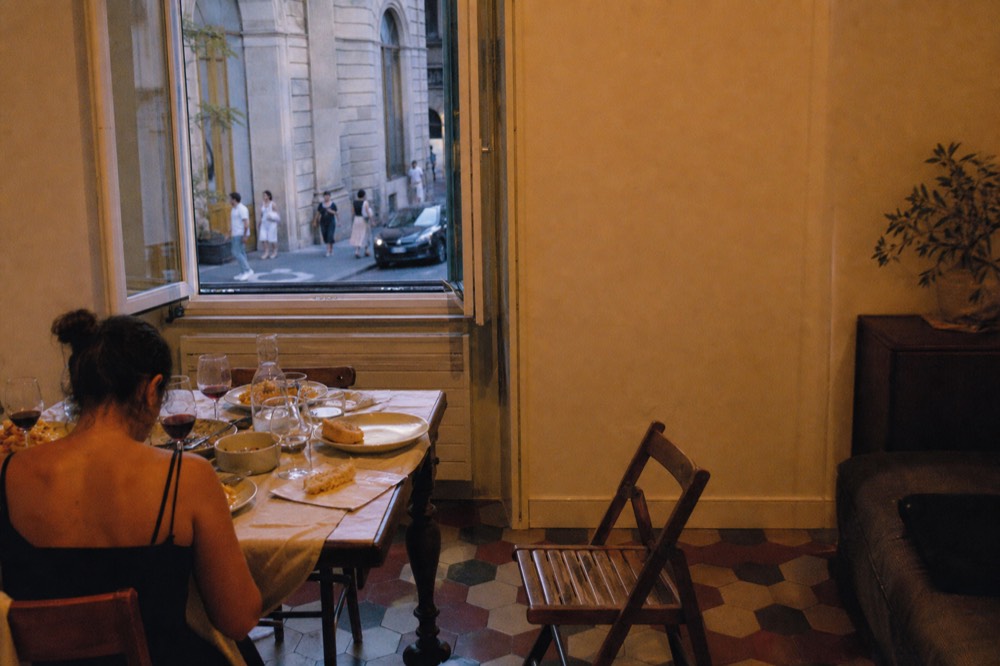 A table set with wine glasses, fresh pasta plates and a rustic loaf