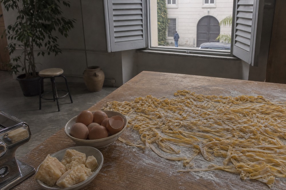 Fresh pasta and ingredients laid out on a wooden table in a Milan cooking school