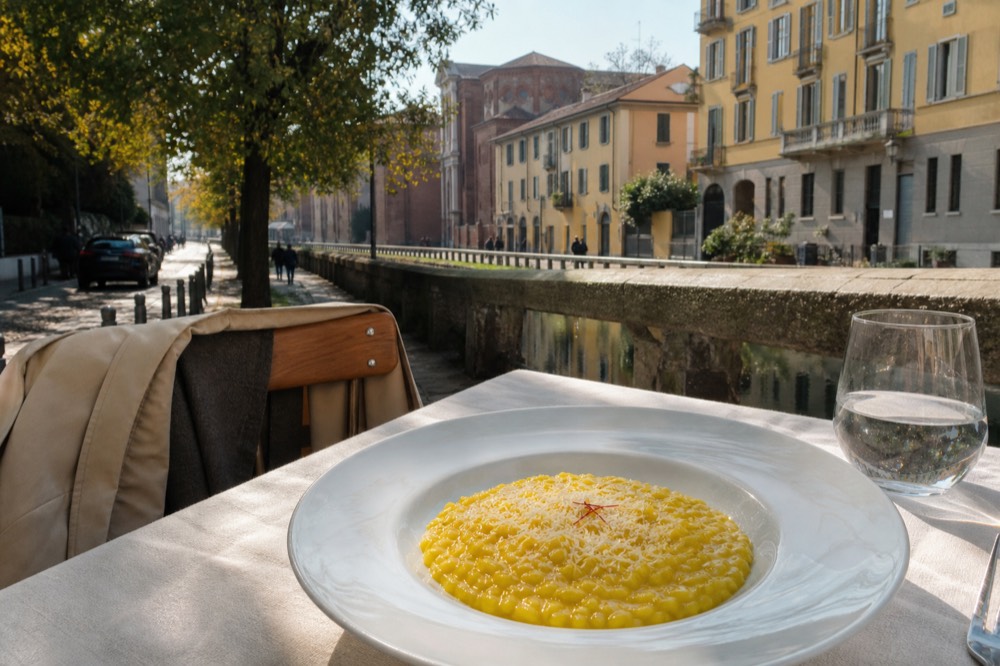 A plate of risotto alla milanese with saffron served on a trattoria table