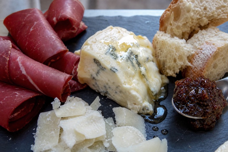 A tasting platter of Lombard salumi and cheese served on a deli counter in Milan