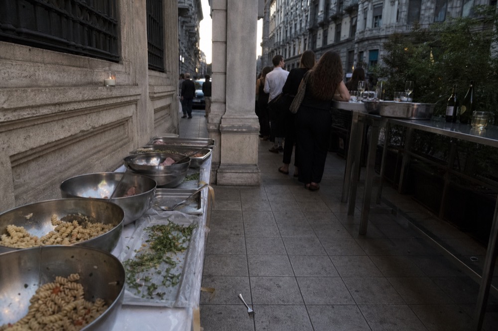Buffet table with bowls of pasta salad, focaccia and cold cuts in a Milanese bar