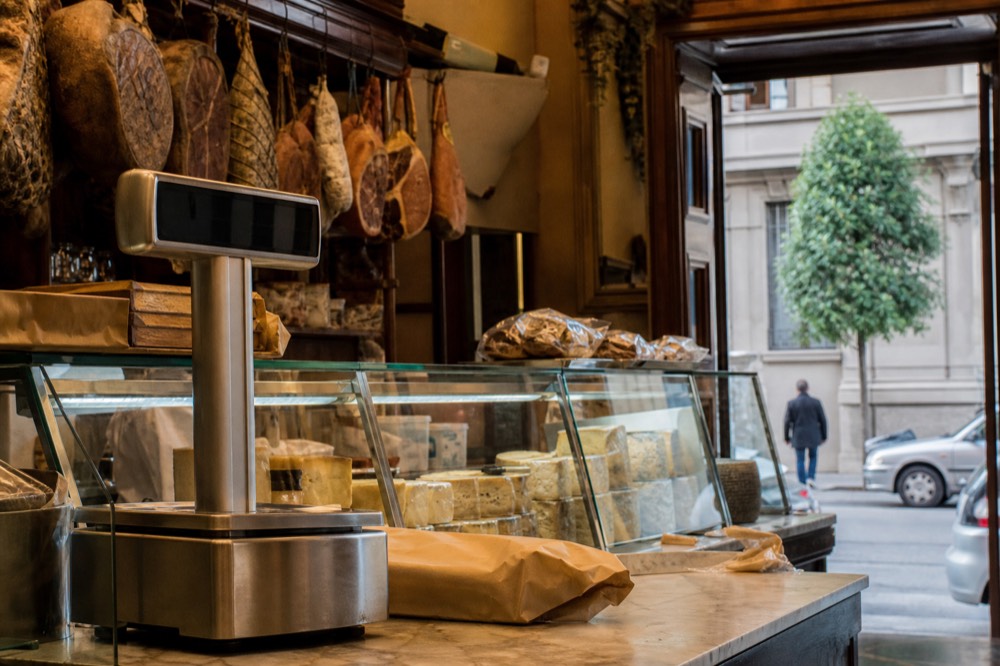 The counter of a historic Milanese delicatessen with cheeses and cured meats