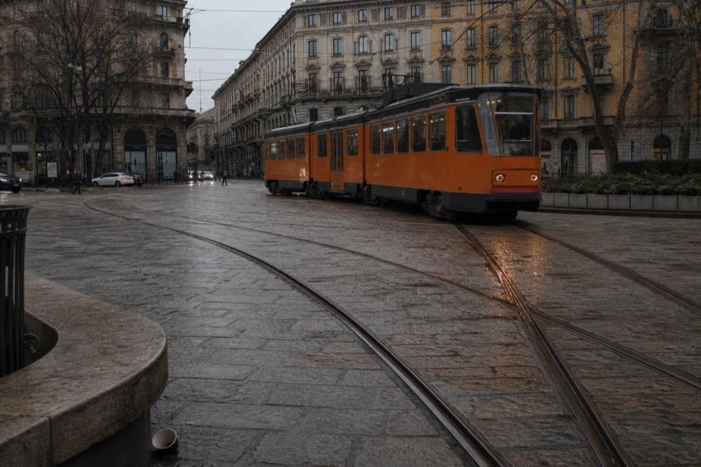 Milan tram passing historic buildings on a city street