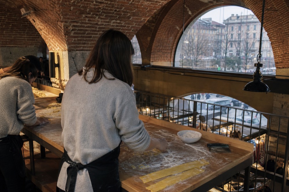 A cooking class in progress inside the food hall with participants making pasta