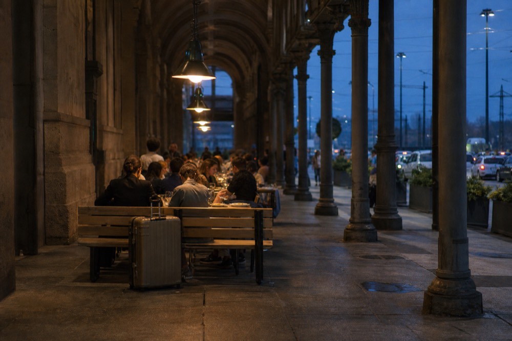 People eating at shared tables inside the food hall with the station's architecture visible