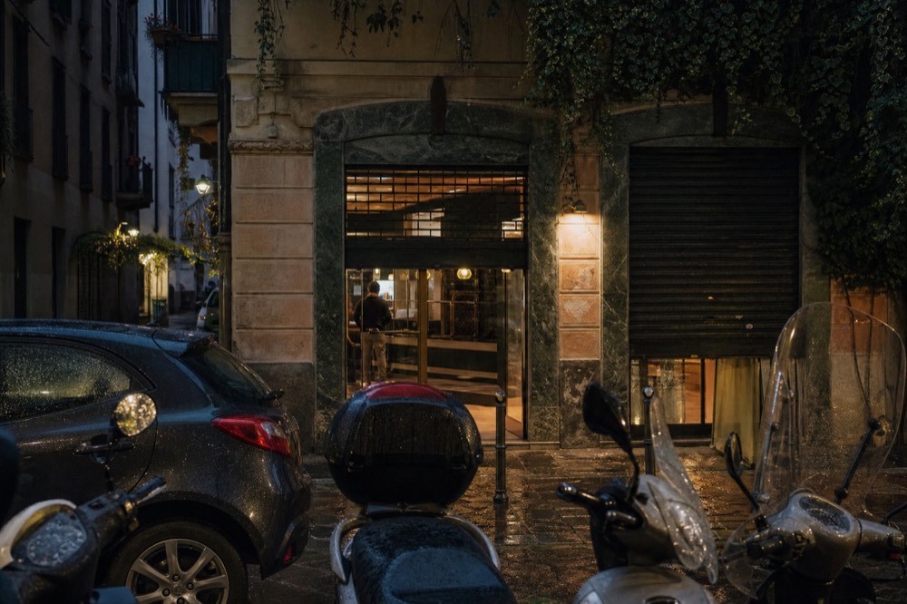 A historic pizzeria storefront on an evening street in Ticinese