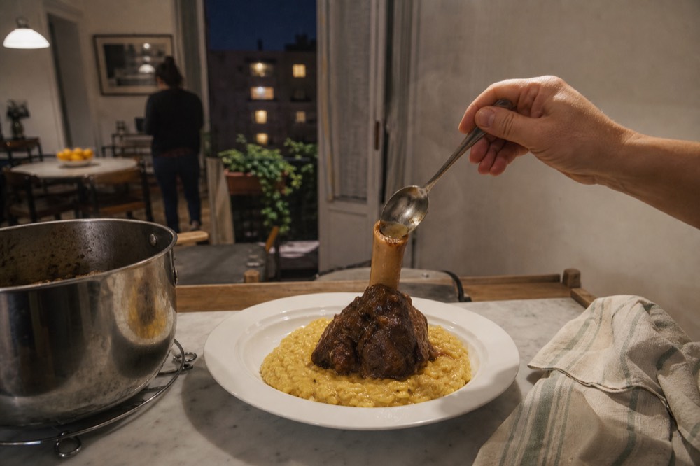 Risotto alla milanese topped with a braised veal shank and a spoonful of marrow