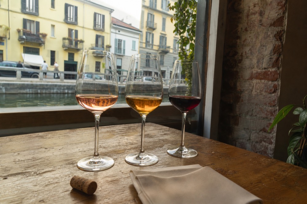 Three wine glasses of different colors on a tasting table